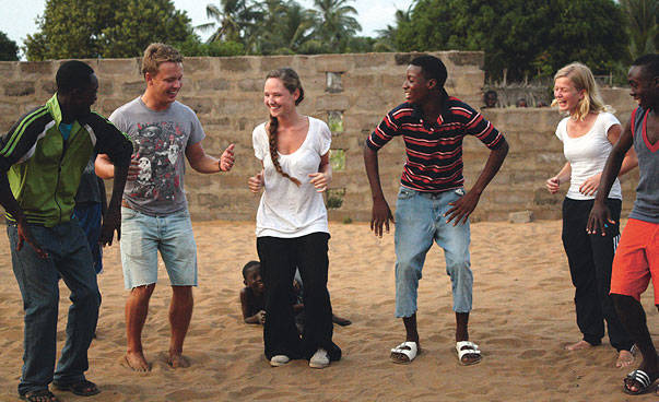 Two white girls and a white boy are playing with three black boys.